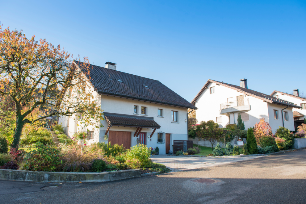 Ein älteres Haus steht in einer Siedlung