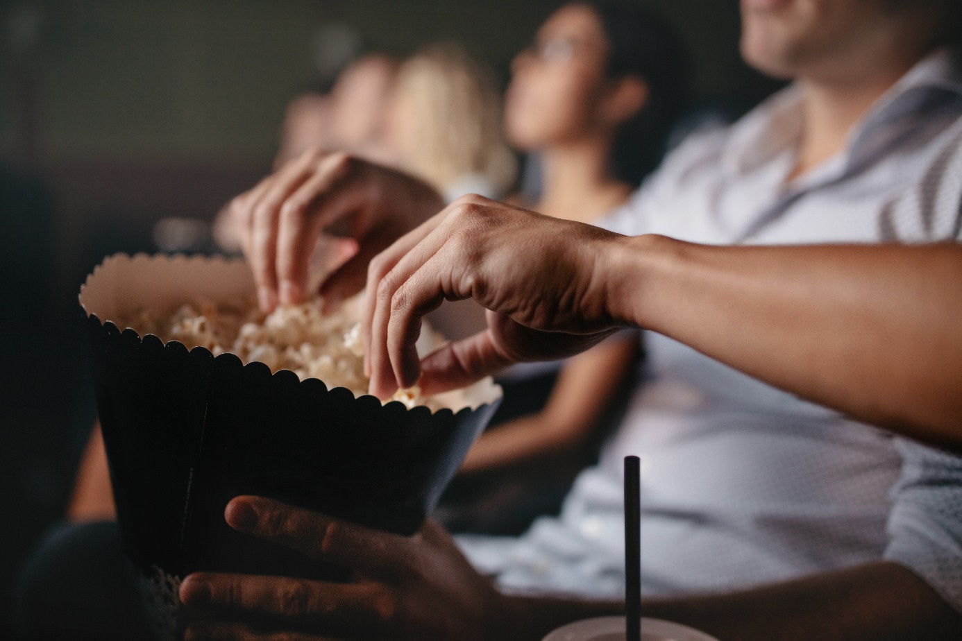 Menschen essen Popcorn im Kino