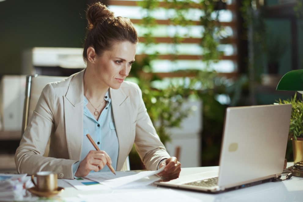 Eine Frau führt eine Online-Wertermittlung am Laptop durch.